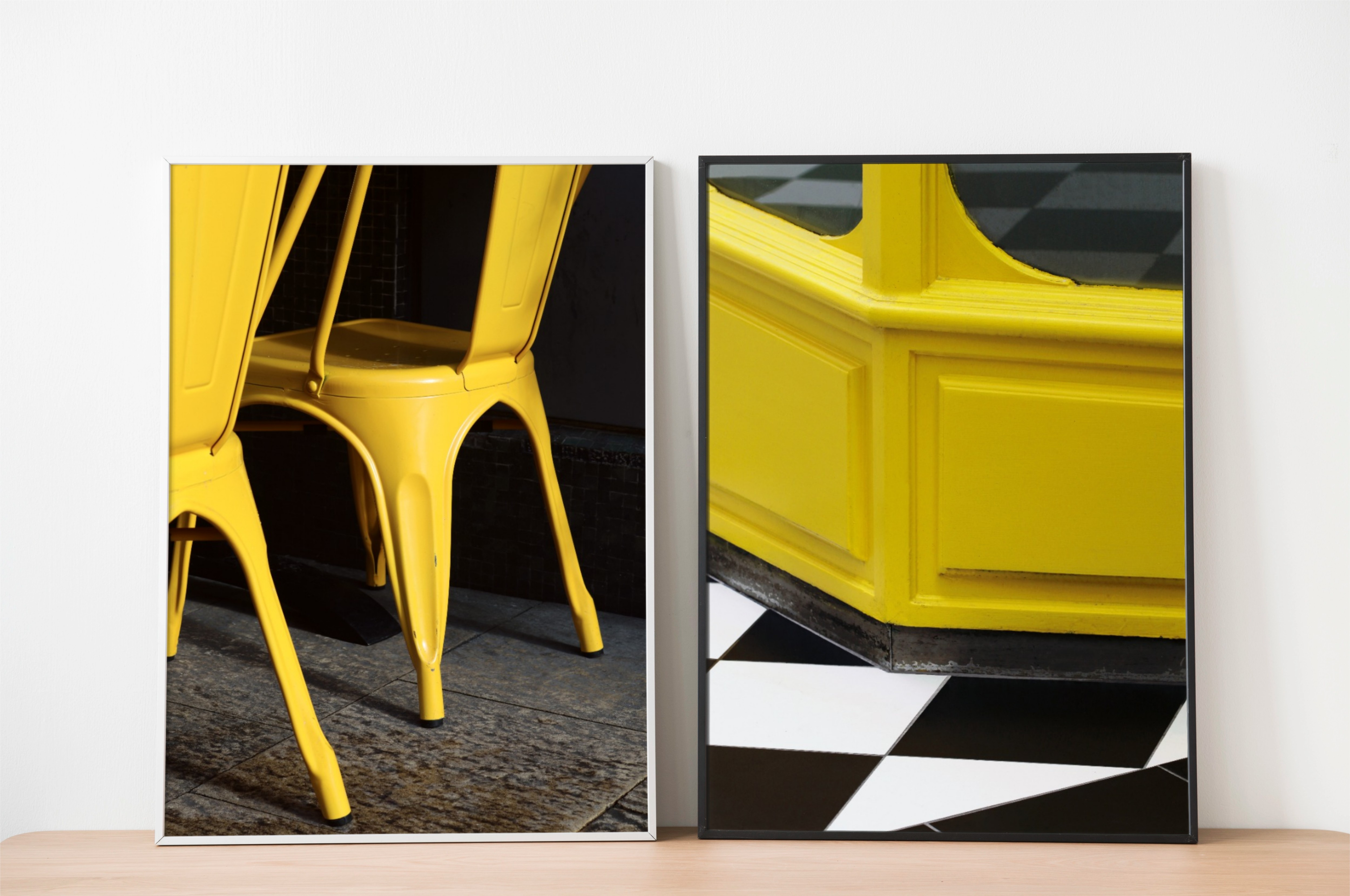 Two framed prints paired by colour — yellow chair and yellow shopfront against contrasting dark backgrounds